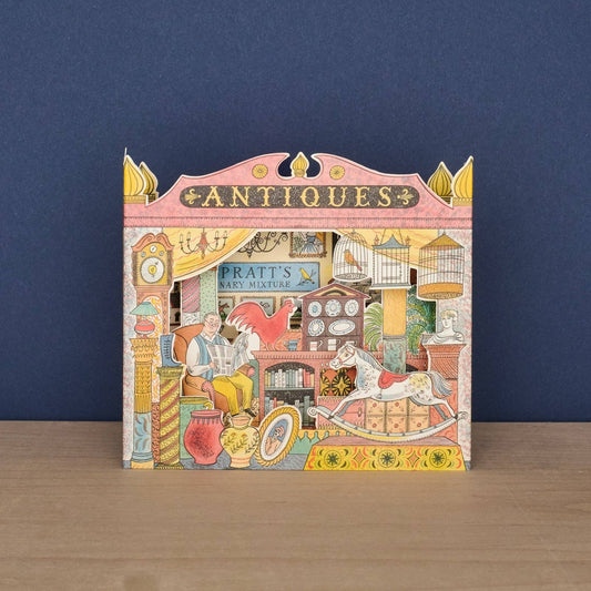 Decorative box with an illustration of an antiques shop on a wooden surface and blue background