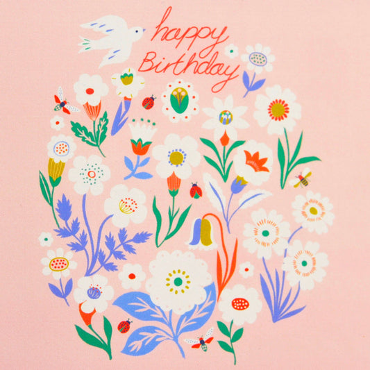 A square greeting card design with a light pink background, featuring a colorful hand-drawn floral illustration and the words 'happy Birthday' in red script at the top.