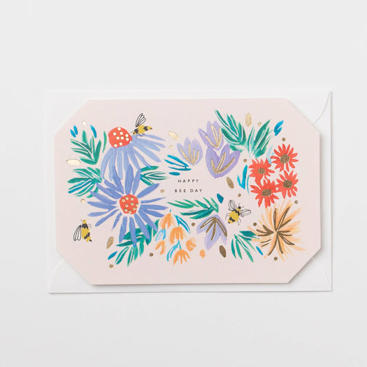 Greeting card with colorful floral design and 'Happy Bee Day' text on a light pink background