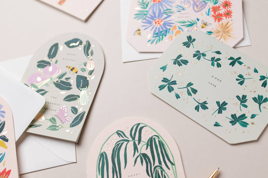 Collection of decorative greeting cards with floral and nature-themed designs on a light background.