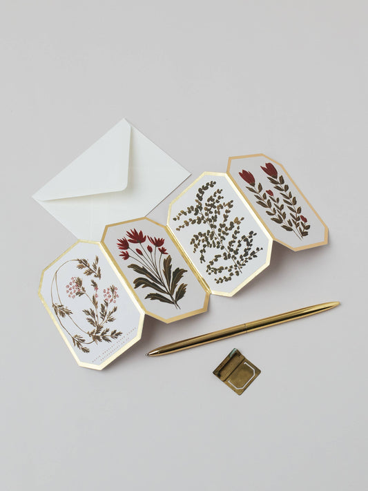 Set of floral cards with a pen and envelope on a light gray background
