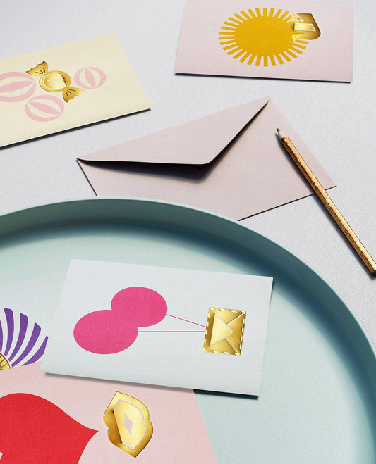 Colorful stationery items including cards and an envelope on a light surface.