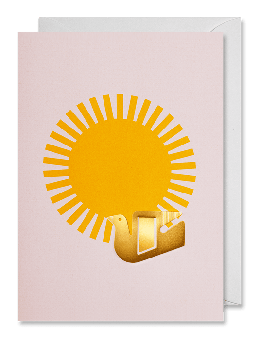 A greeting card with a pale pink background, featuring a yellow sun and a gold bird holding a letter, shown with a white envelope behind it on a dark green background.