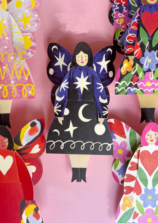 Colorful paper cutout of a fairy with star design on a pink background