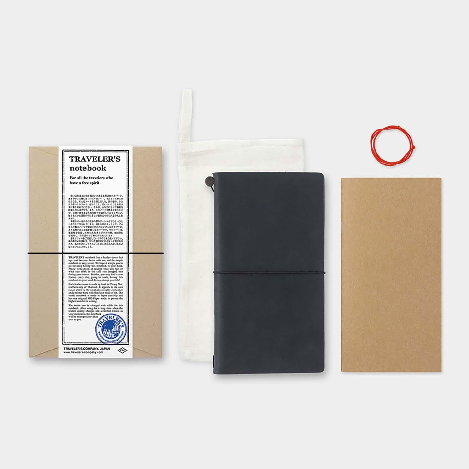 Black travel notebook with a white pouch, red string, and cardboard packaging on a white background