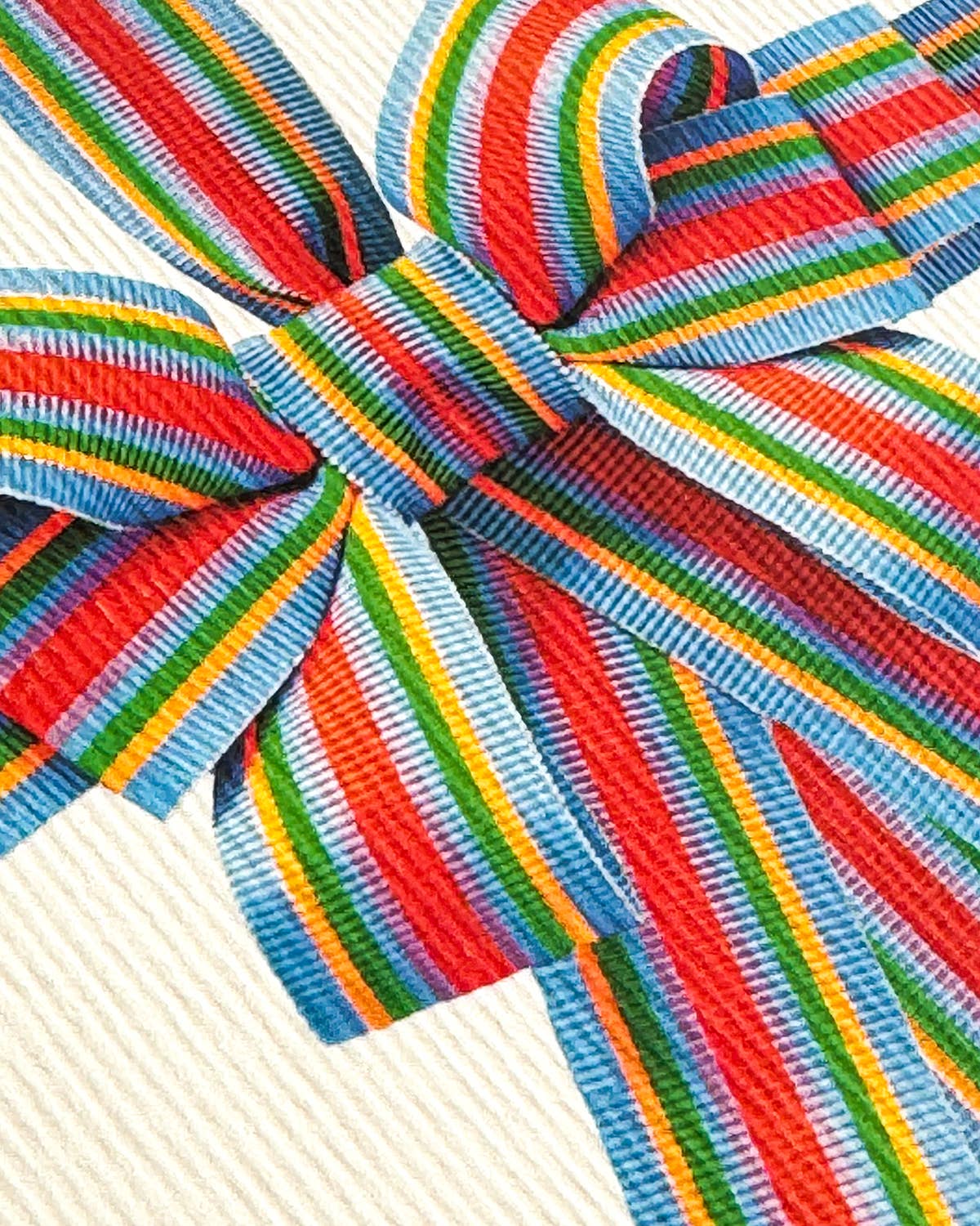 Close-up of a colorful striped bow with red, green, blue, and yellow stripes on a white background.
