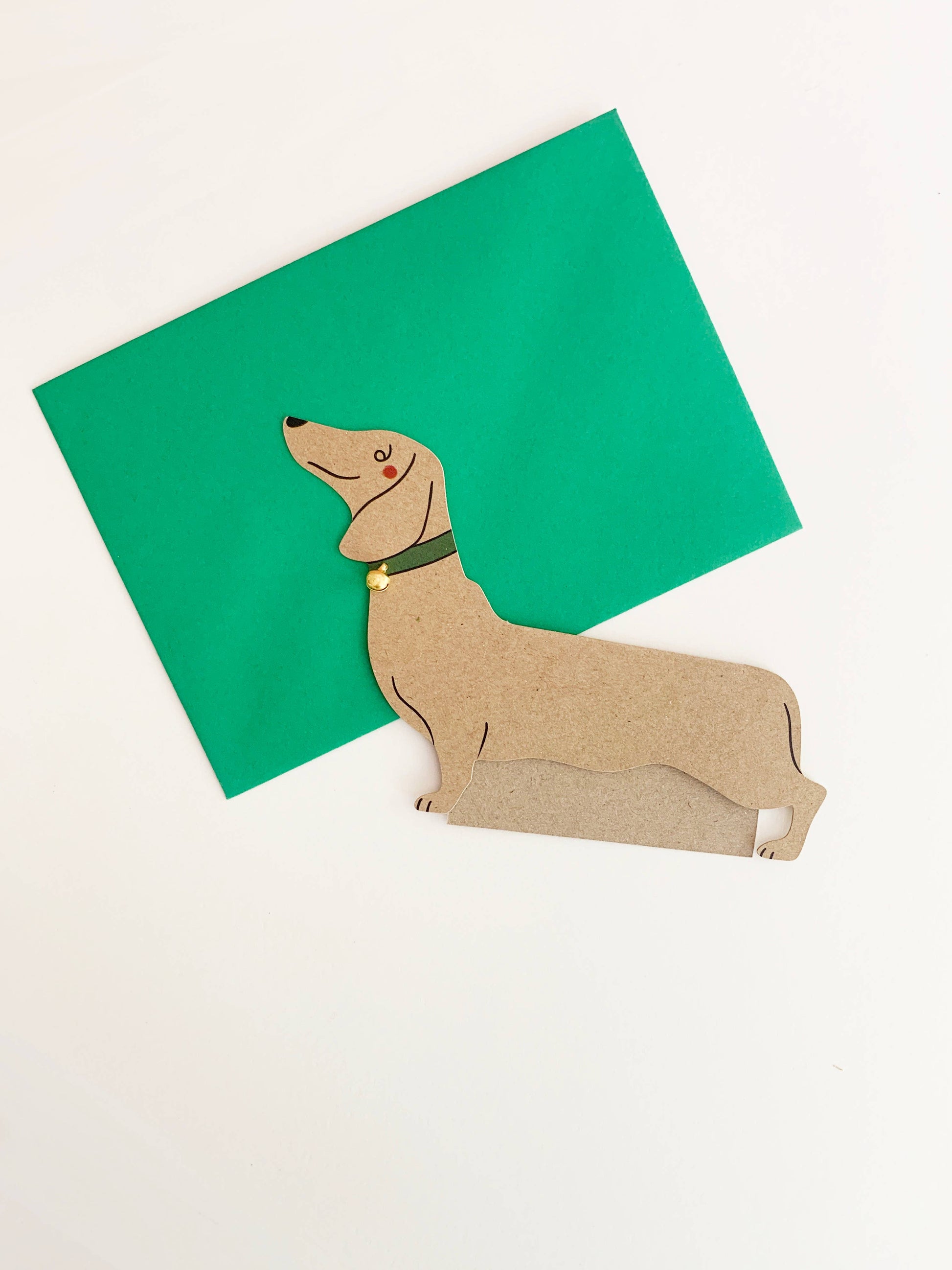 Card with a dachshund illustration on a green card against a white background