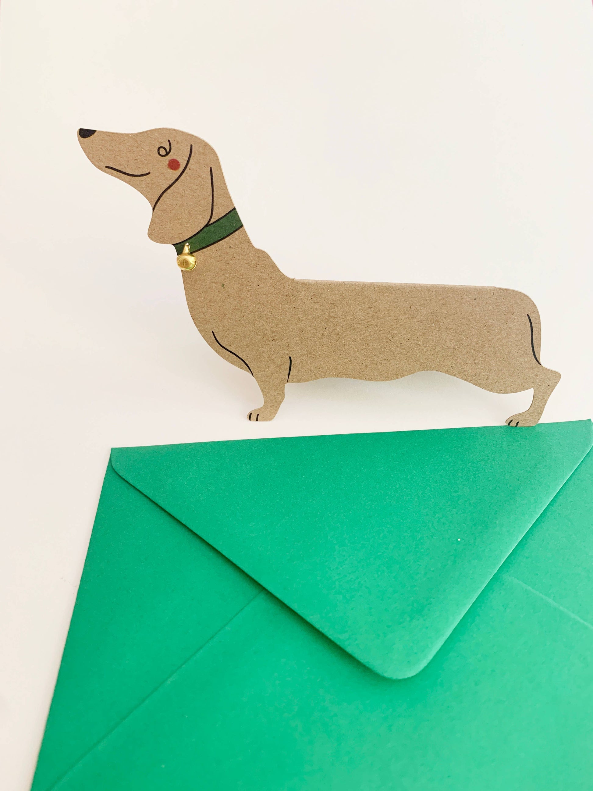 Card with a dachshund design on top of a green envelope