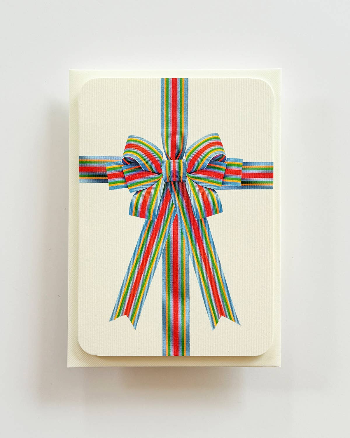 Card with a colorful striped bow on a light background