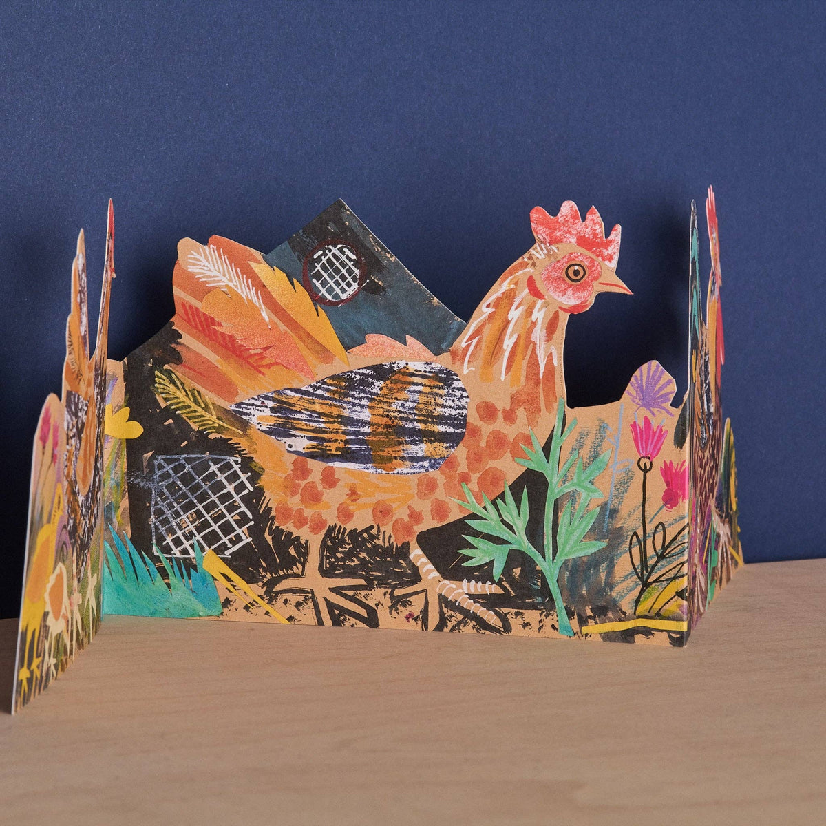Colorful 3D paper sculpture of a rooster with floral elements on a blue background