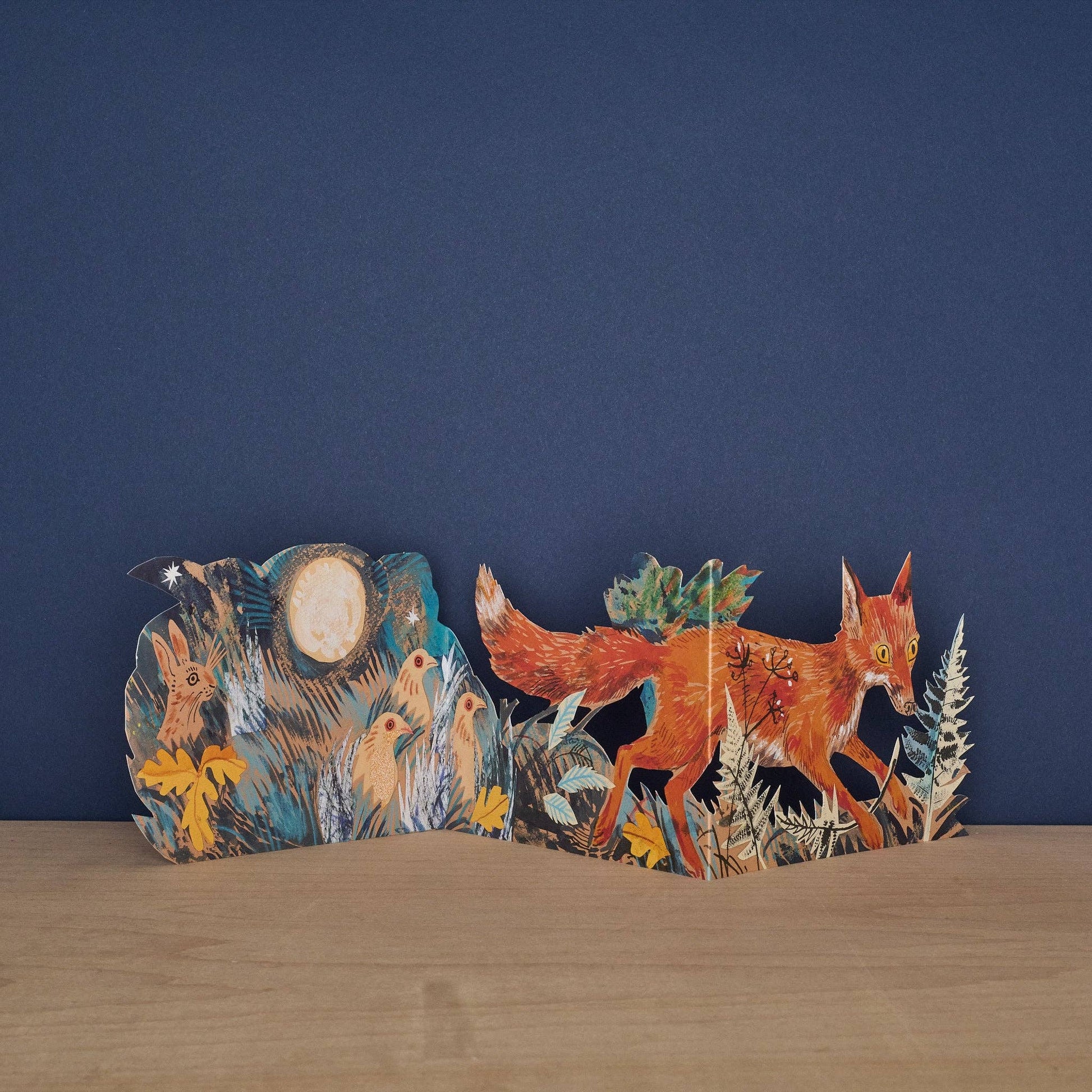 Wooden fox figure with a natural landscape design on a blue background