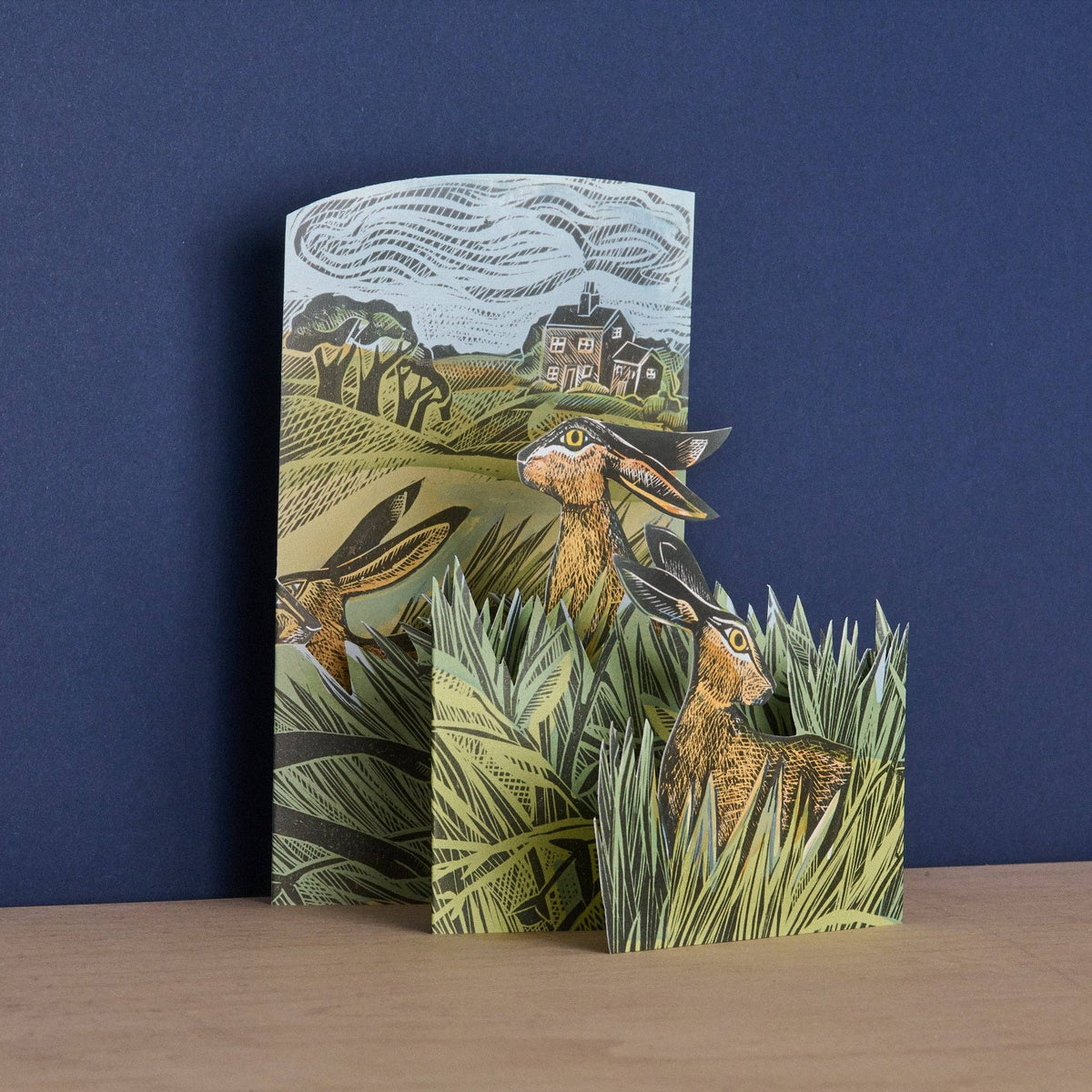 Card with a fox design on a grassy field against a blue background