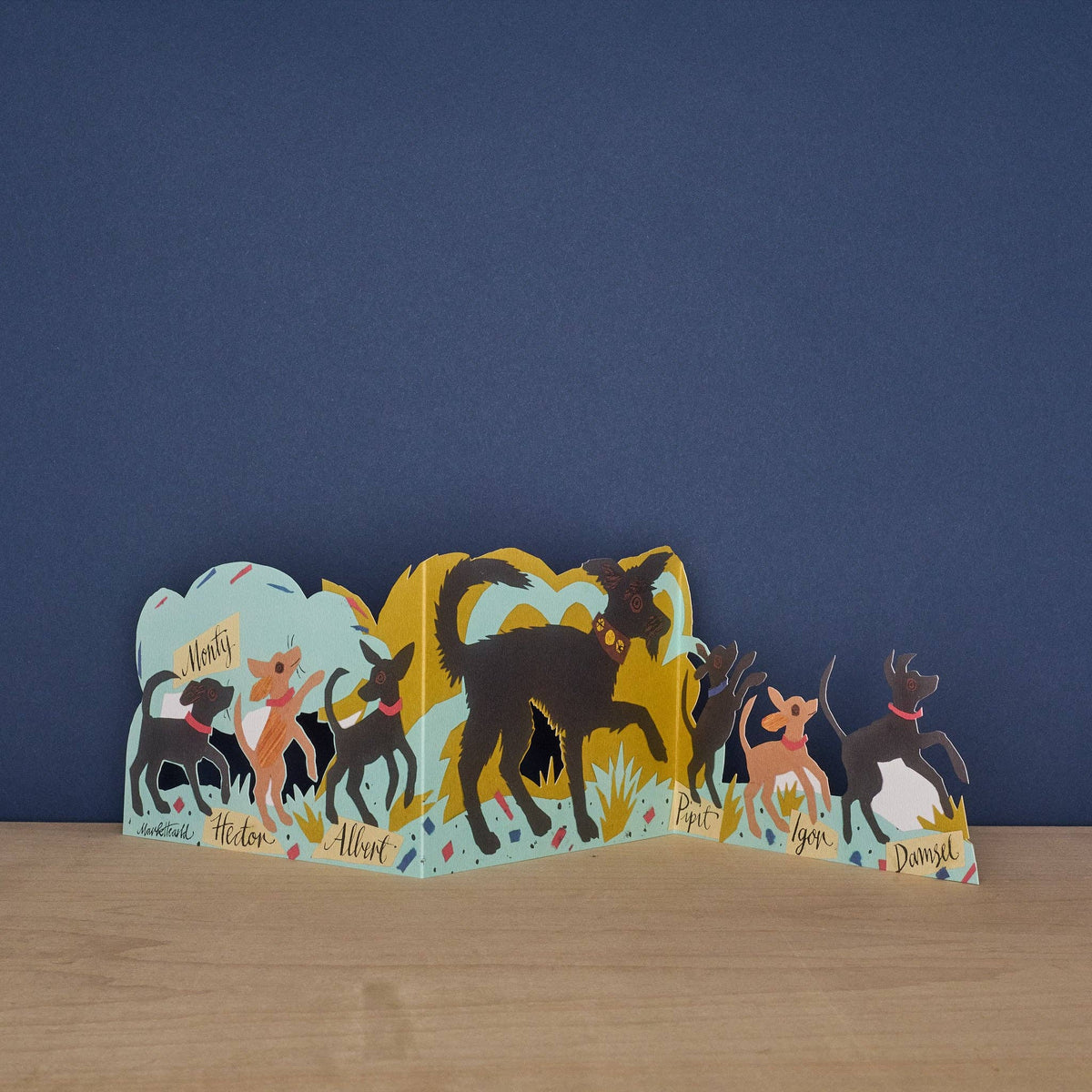 Set of dog-shaped nameplates with illustrations on a wooden surface and blue background