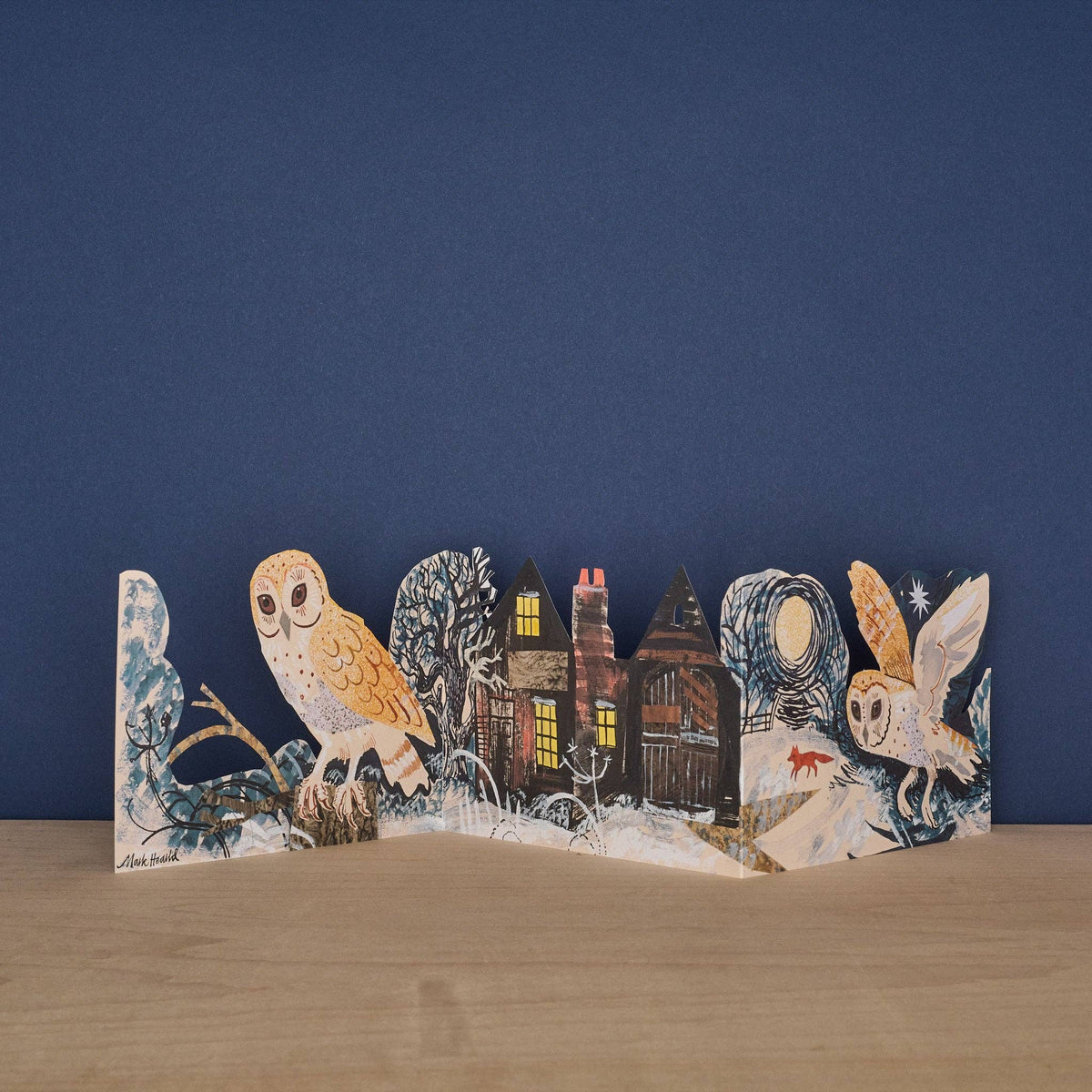 Wooden cutout with owl and house design on a blue background