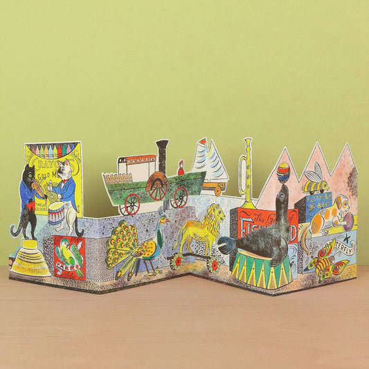 A colorful 3D pop-up cardboard book about The Great Train Robbery, displayed on a wooden surface against a light green background.