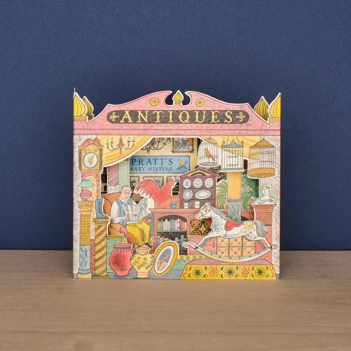 Decorative box with an illustration of an antiques shop on a wooden surface and blue background