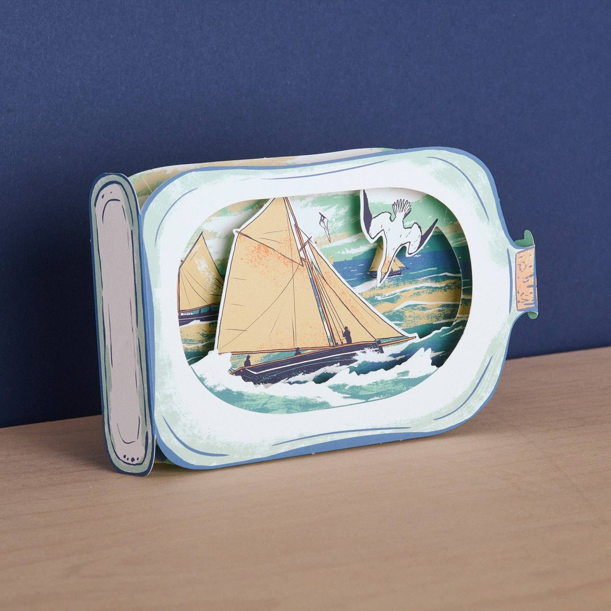 Decorative tray with a sailboat design on a wooden surface and blue background