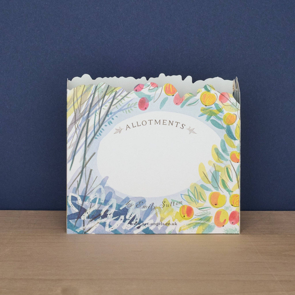 Card with floral design and text on a wooden surface against a blue wall