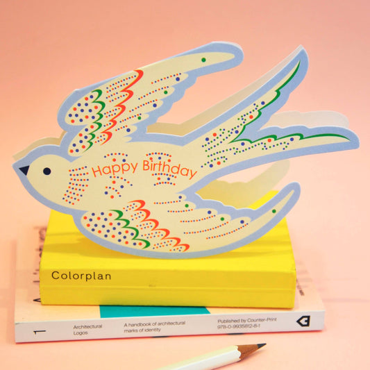 Colorful bird-shaped card with 'Happy Birthday' text on a pink background