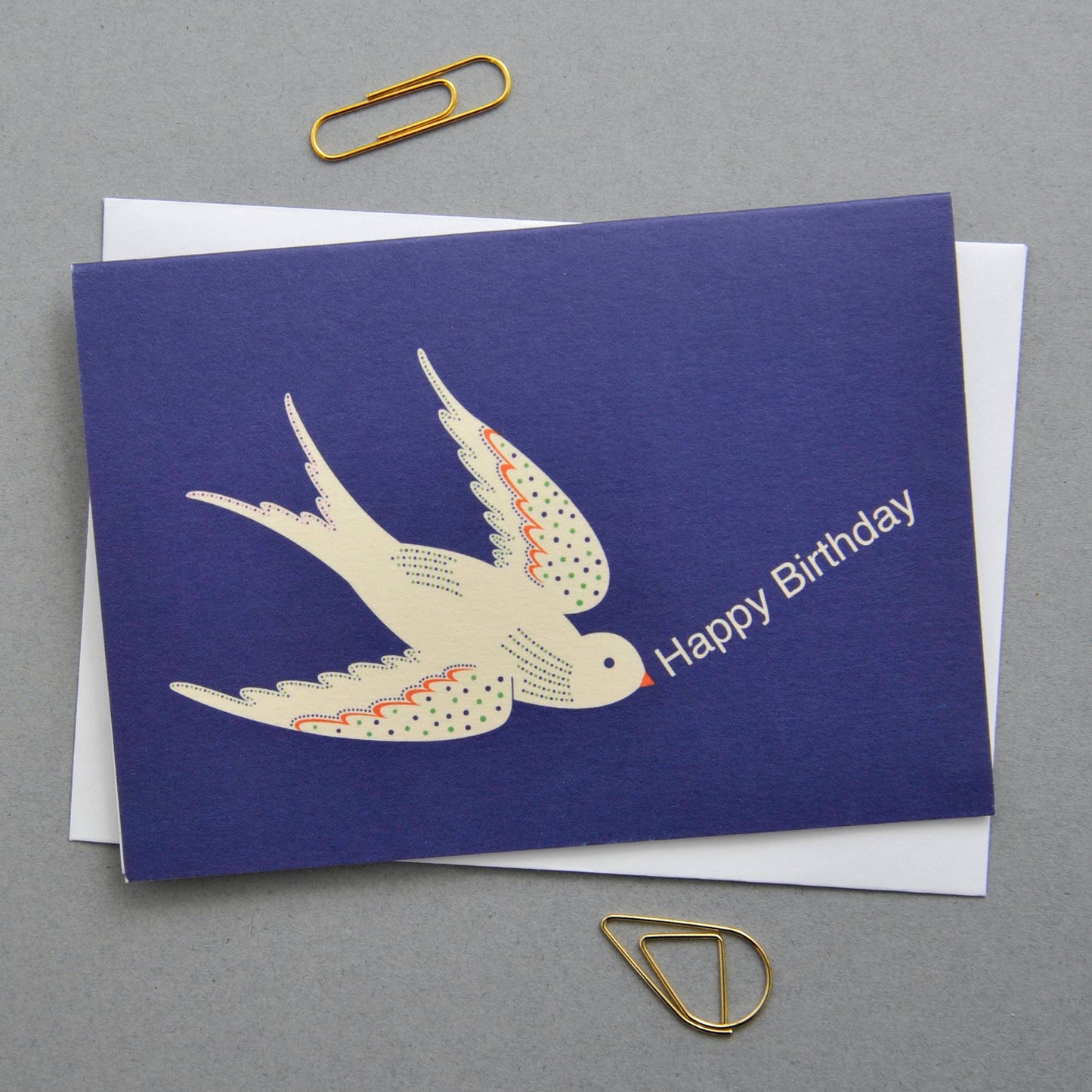 Blue birthday card with swallow illustration and 'Happy Birthday' text on a gray background.