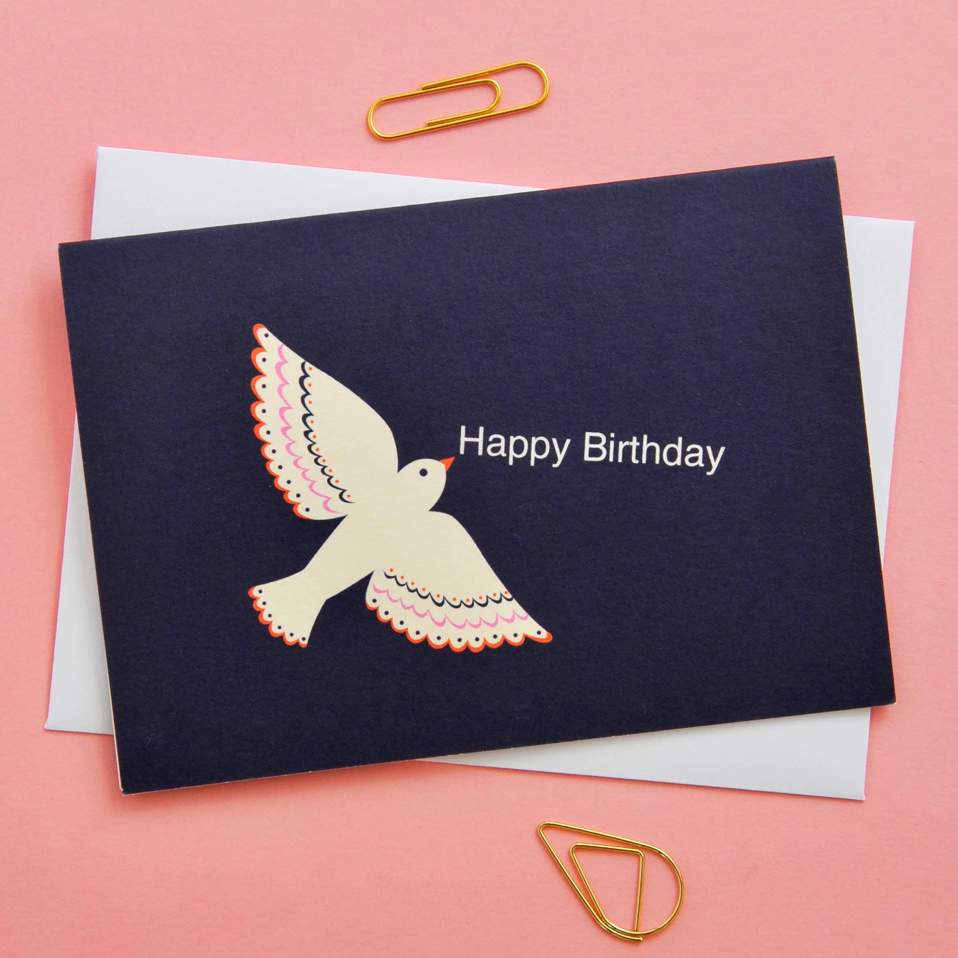 Navy blue birthday card with a dove illustration and 'Happy Birthday' text on a pink background.