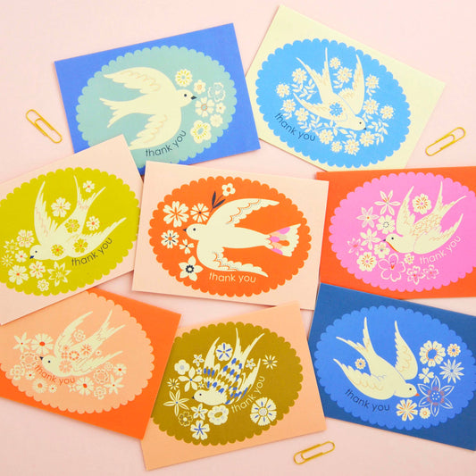 Set of colorful greeting cards with bird illustrations and 'thank you' text on a pink background.
