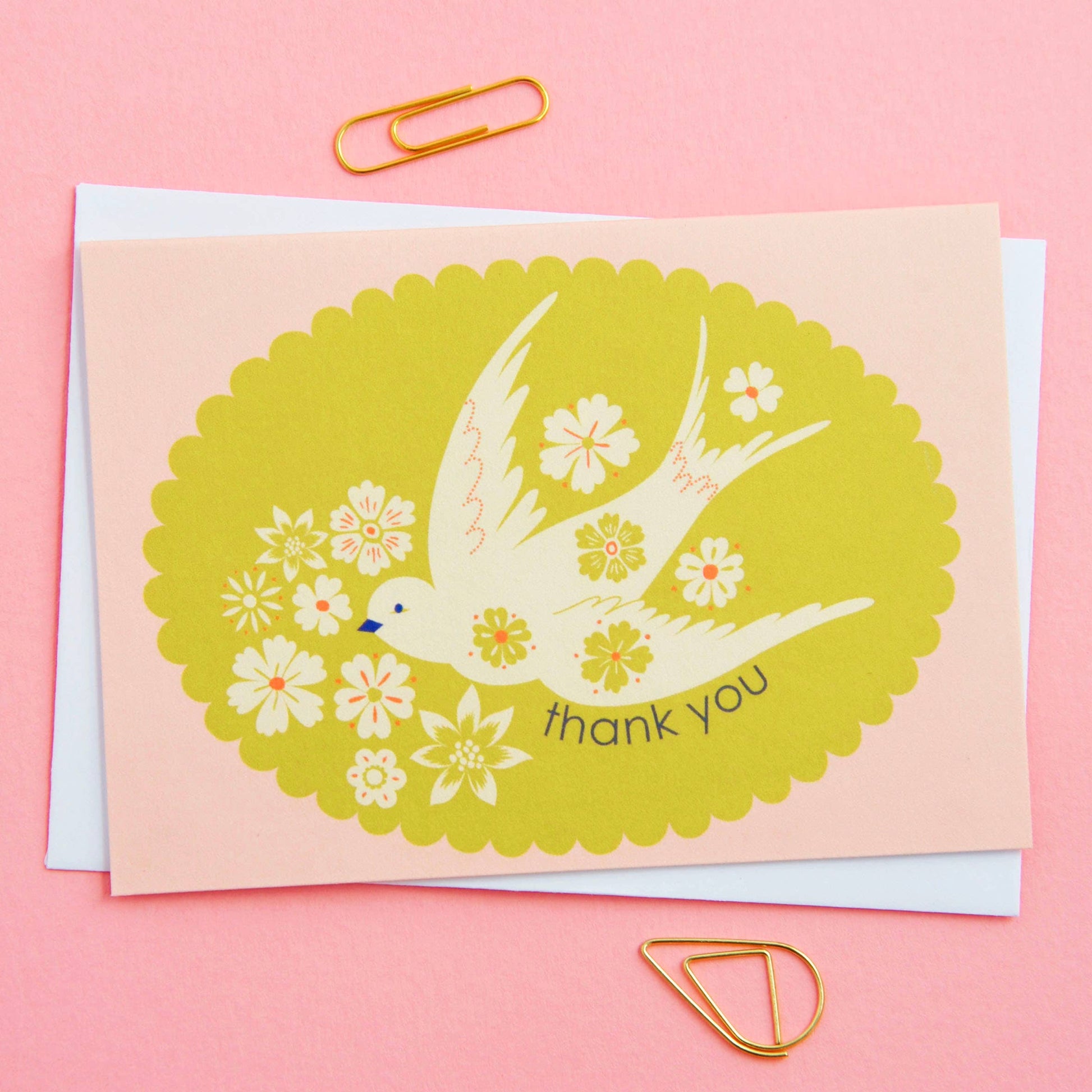 Greeting card with a bird and floral design on a pink background