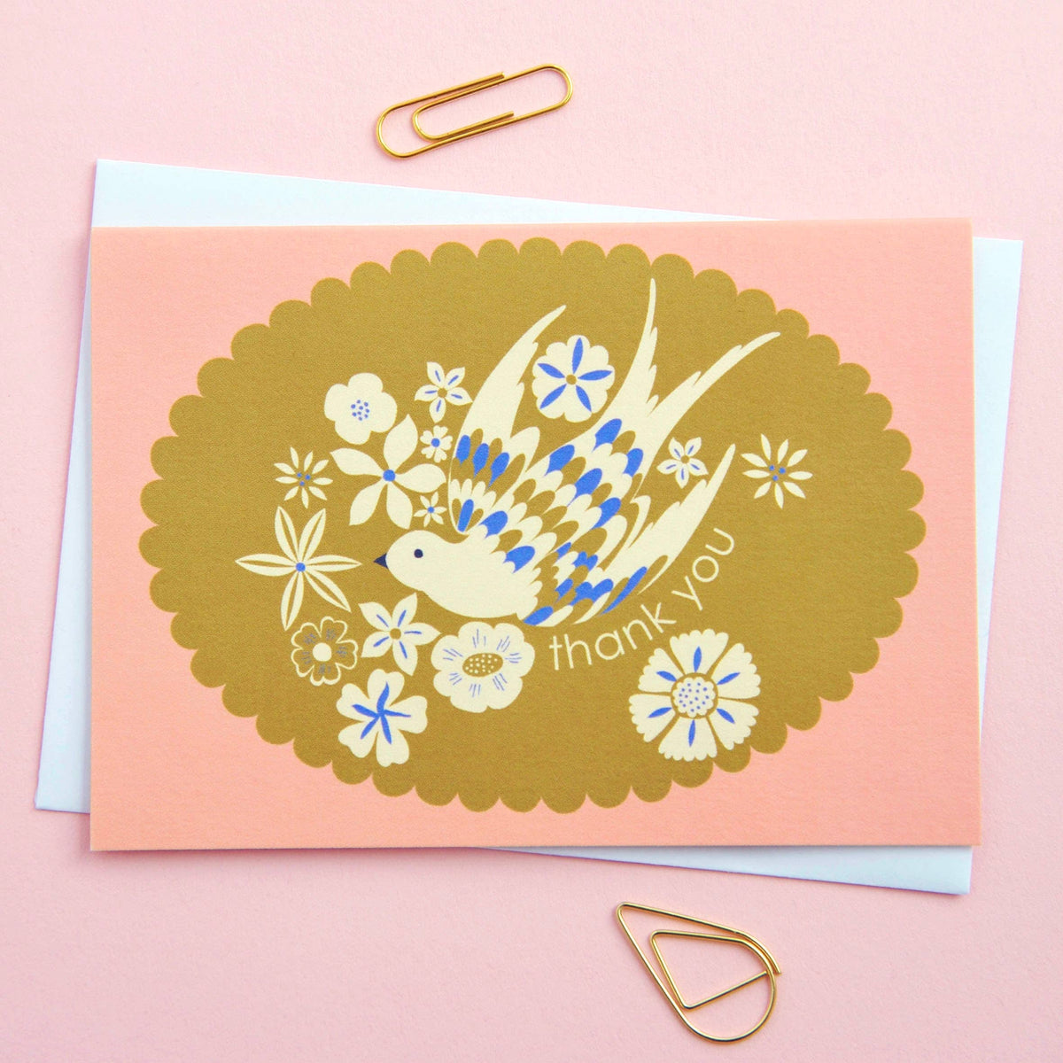 Greeting card with a bird and floral design on a pink background