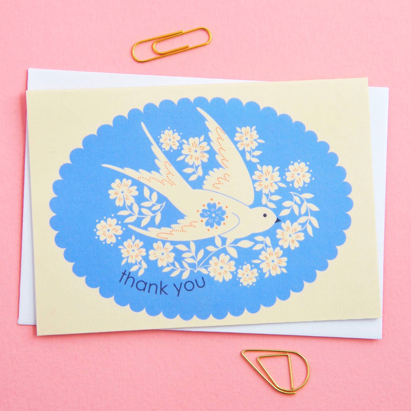 Greeting card with a swallow and floral design on a pink background