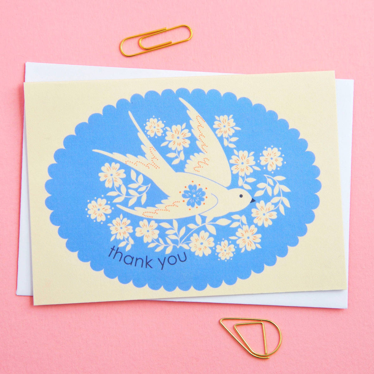 Greeting card with a swallow and floral design on a pink background