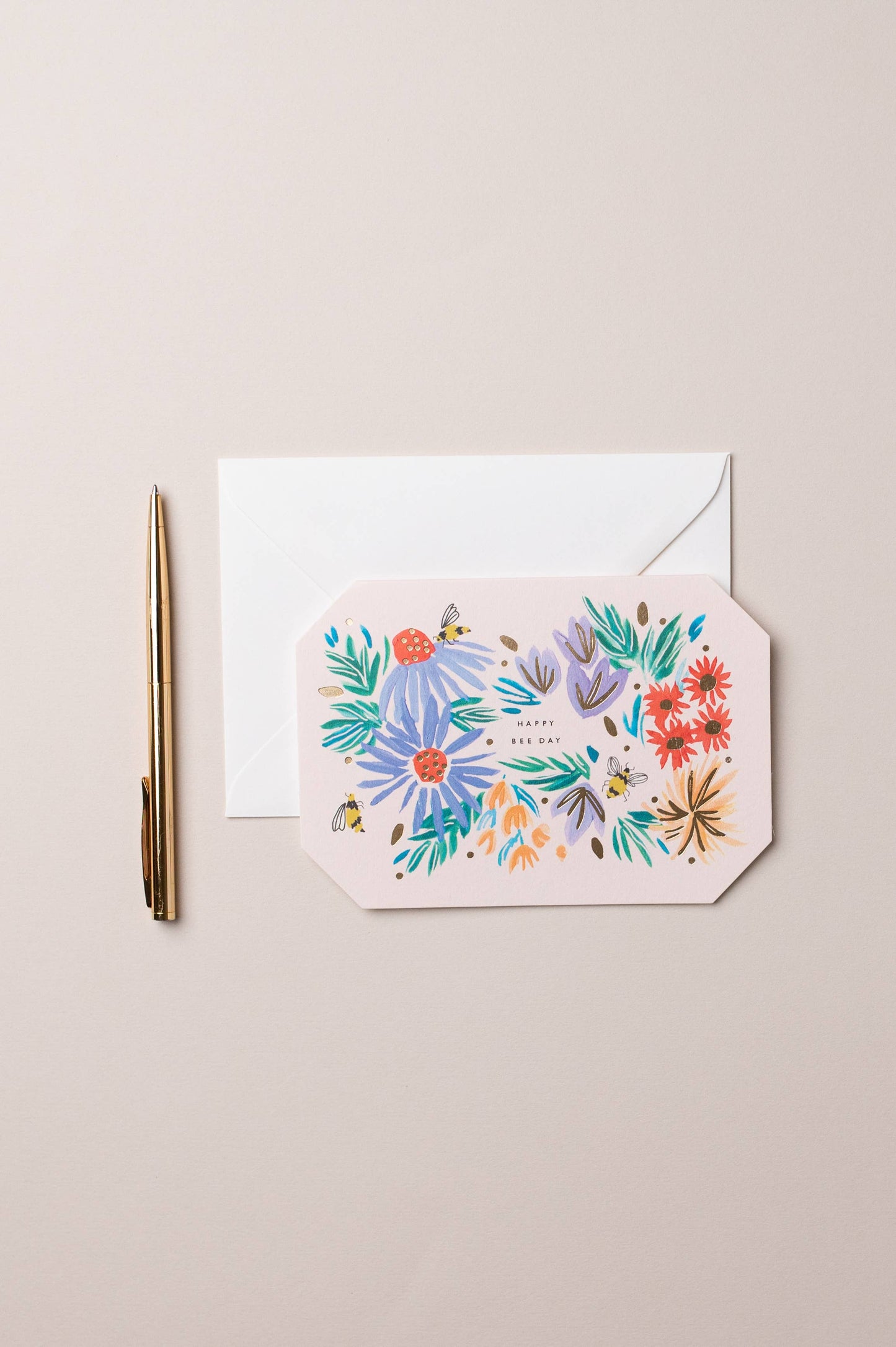 Floral card with envelope and pen on a beige background