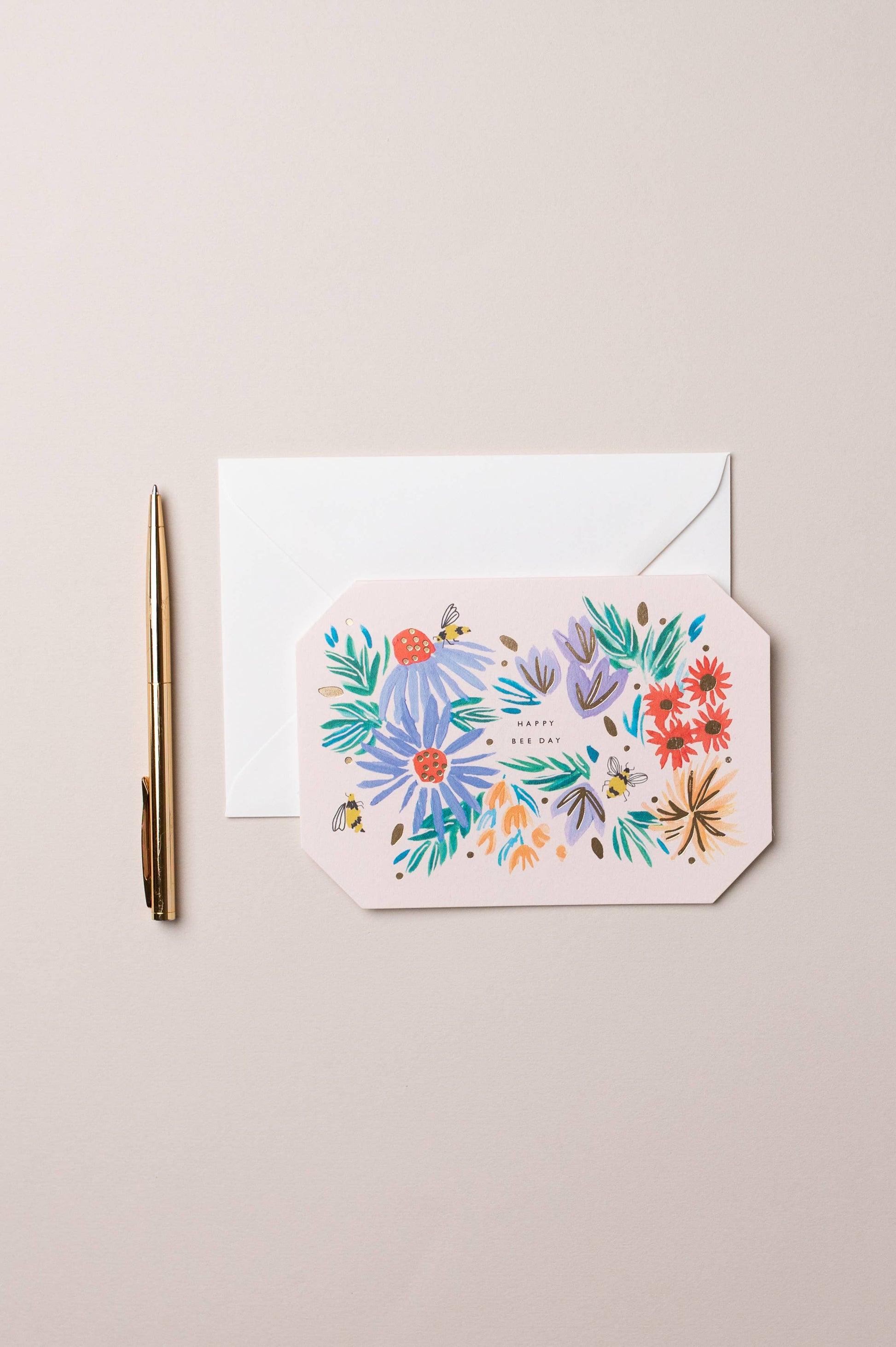 Floral card with envelope and pen on a beige background
