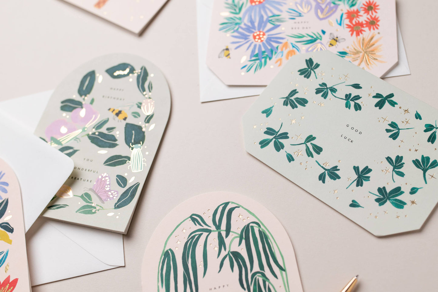 Collection of decorative greeting cards with floral and nature-themed designs on a light background.