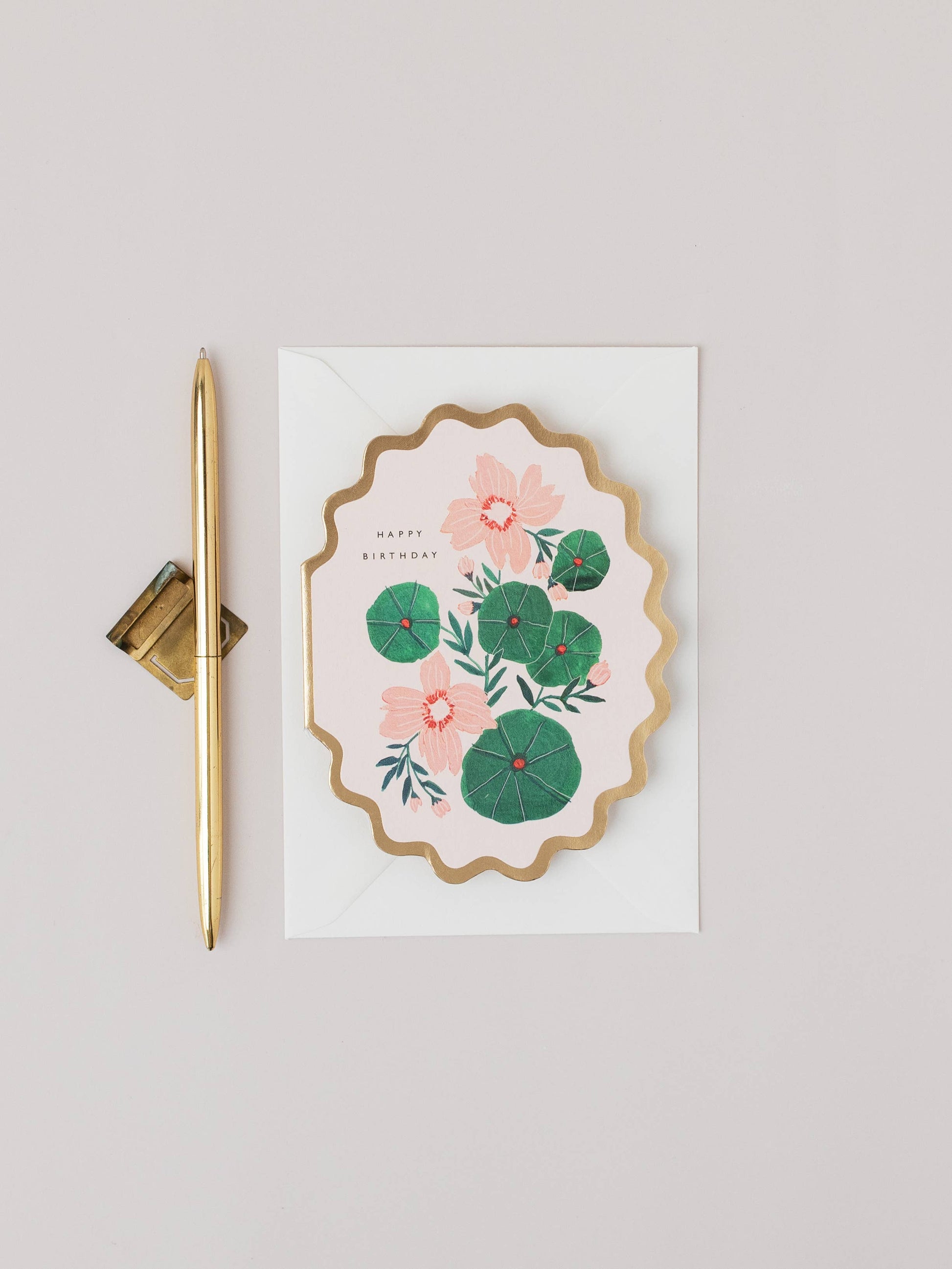 Floral card with gold pen on a light gray background