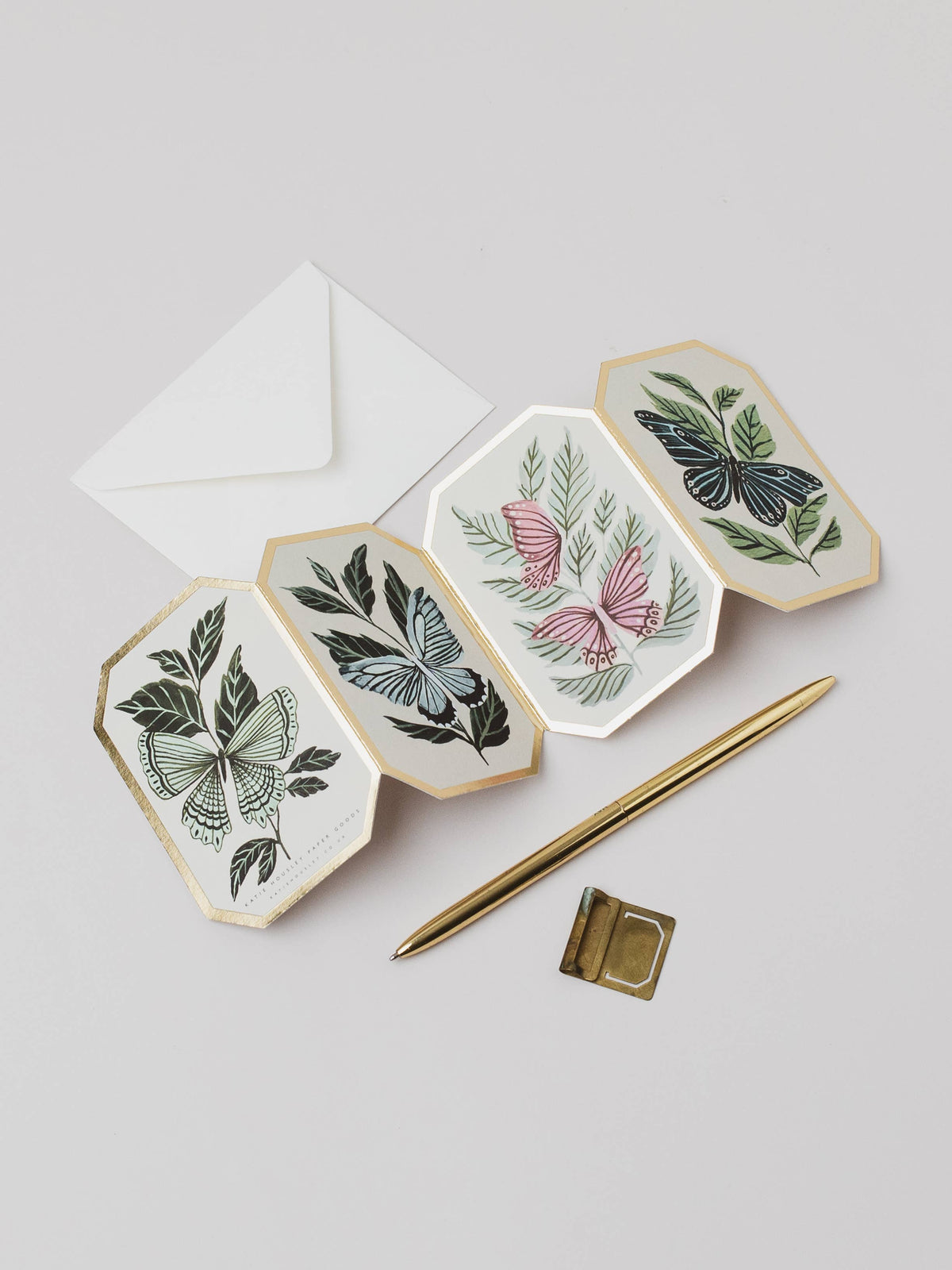 Hexagonal ceramic plates with botanical designs on a light gray background. Butterflies