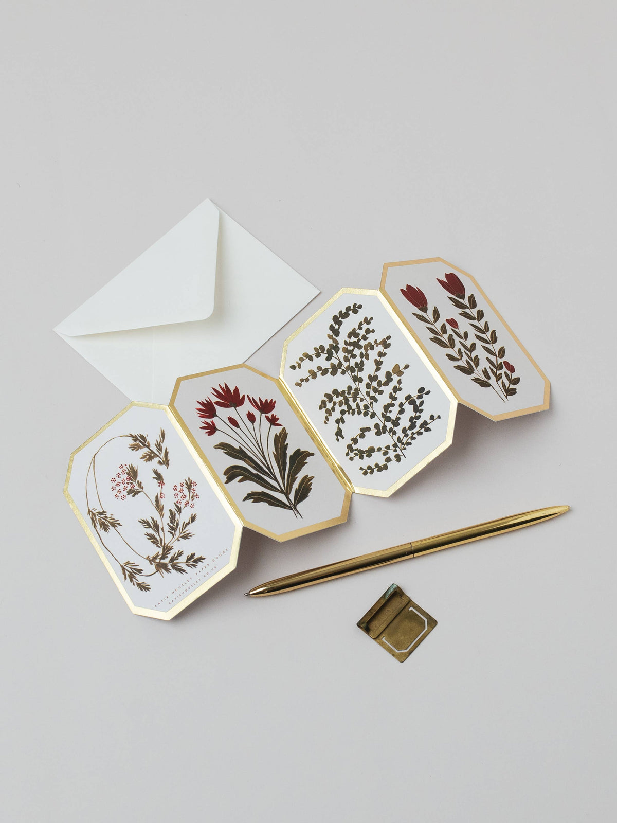Set of floral cards with a pen and envelope on a light gray background
