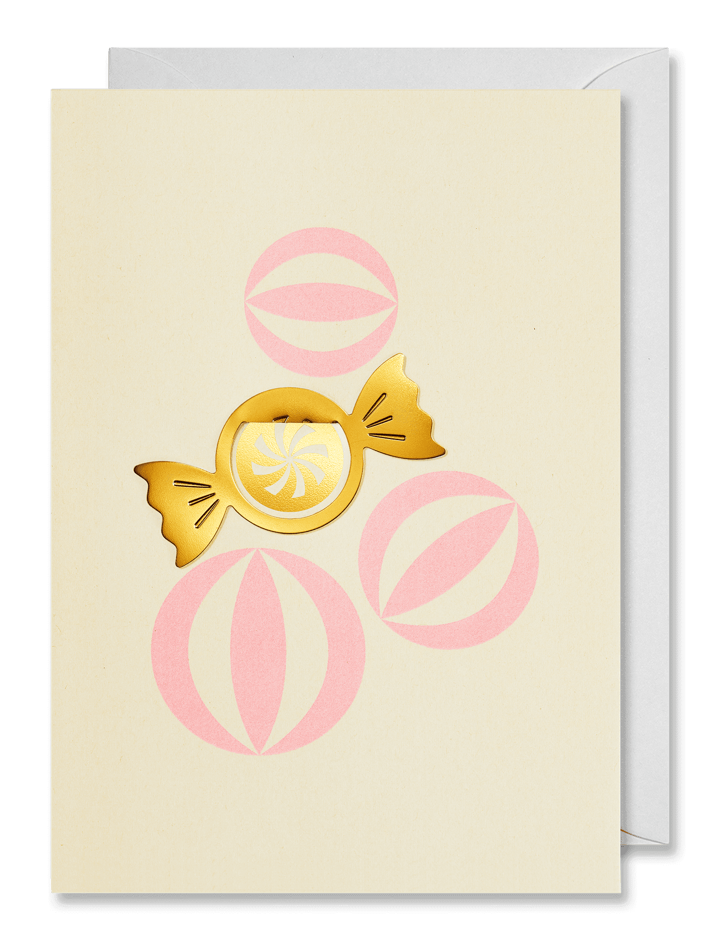 A cream-colored greeting card featuring a gold foil wrapped candy and pink circular patterns, shown with a white envelope behind it on a dark green background.