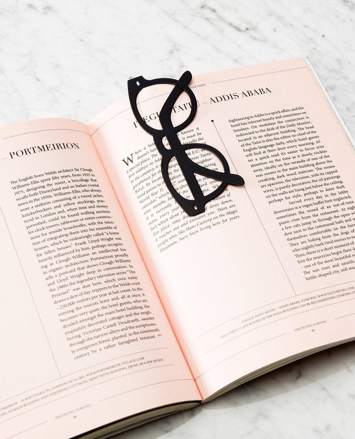 Black eyeglasses-shaped bookmark on an open book