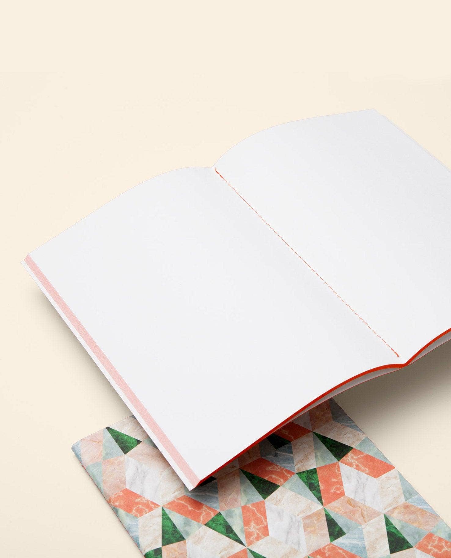 Open book with a geometric patterned page on a beige background
