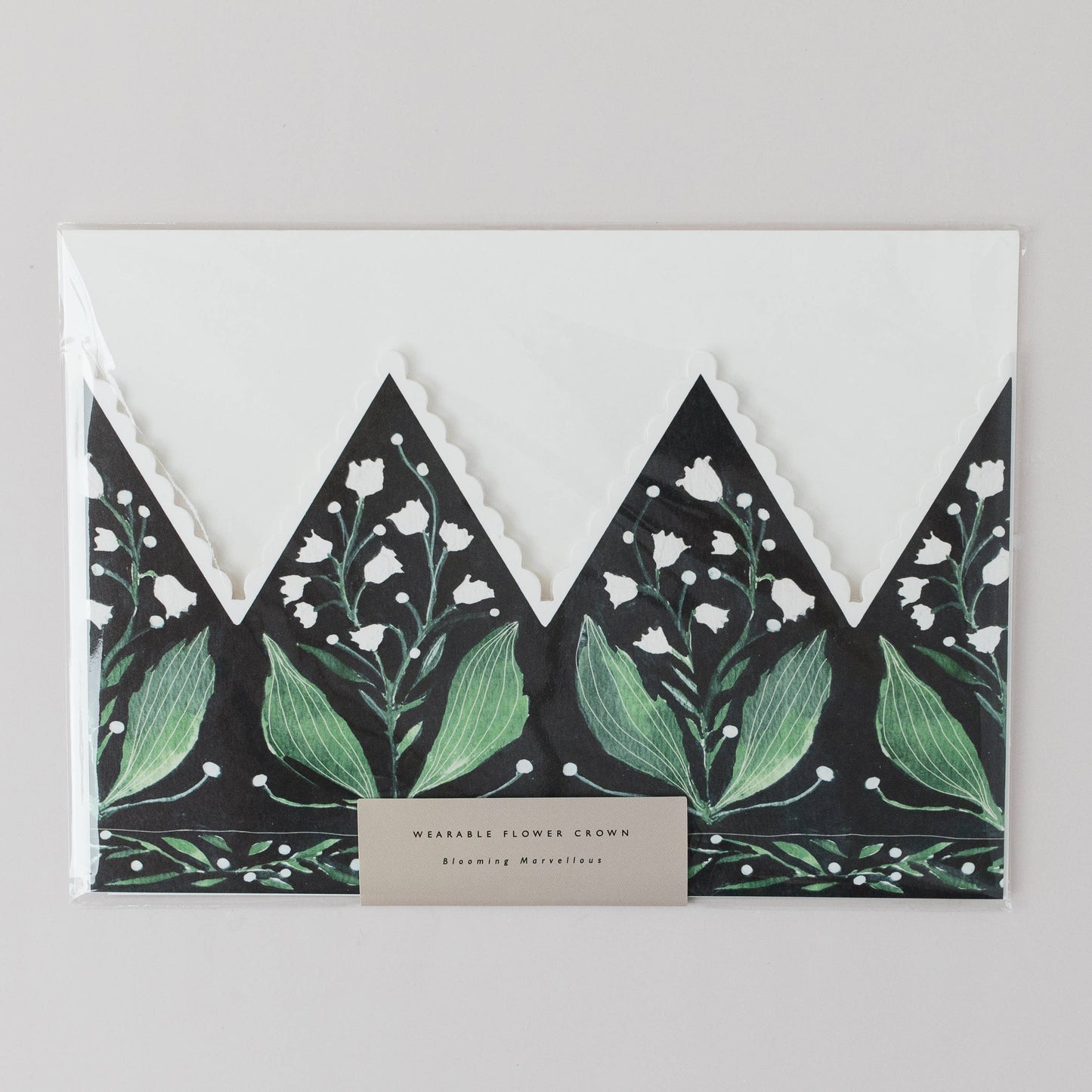Floral-patterned envelope with green leaves and white flowers on a gray background