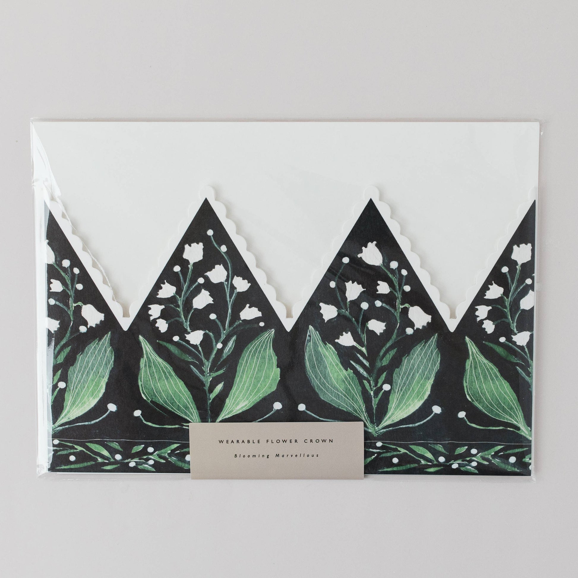 Floral-patterned envelope with green leaves and white flowers on a gray background