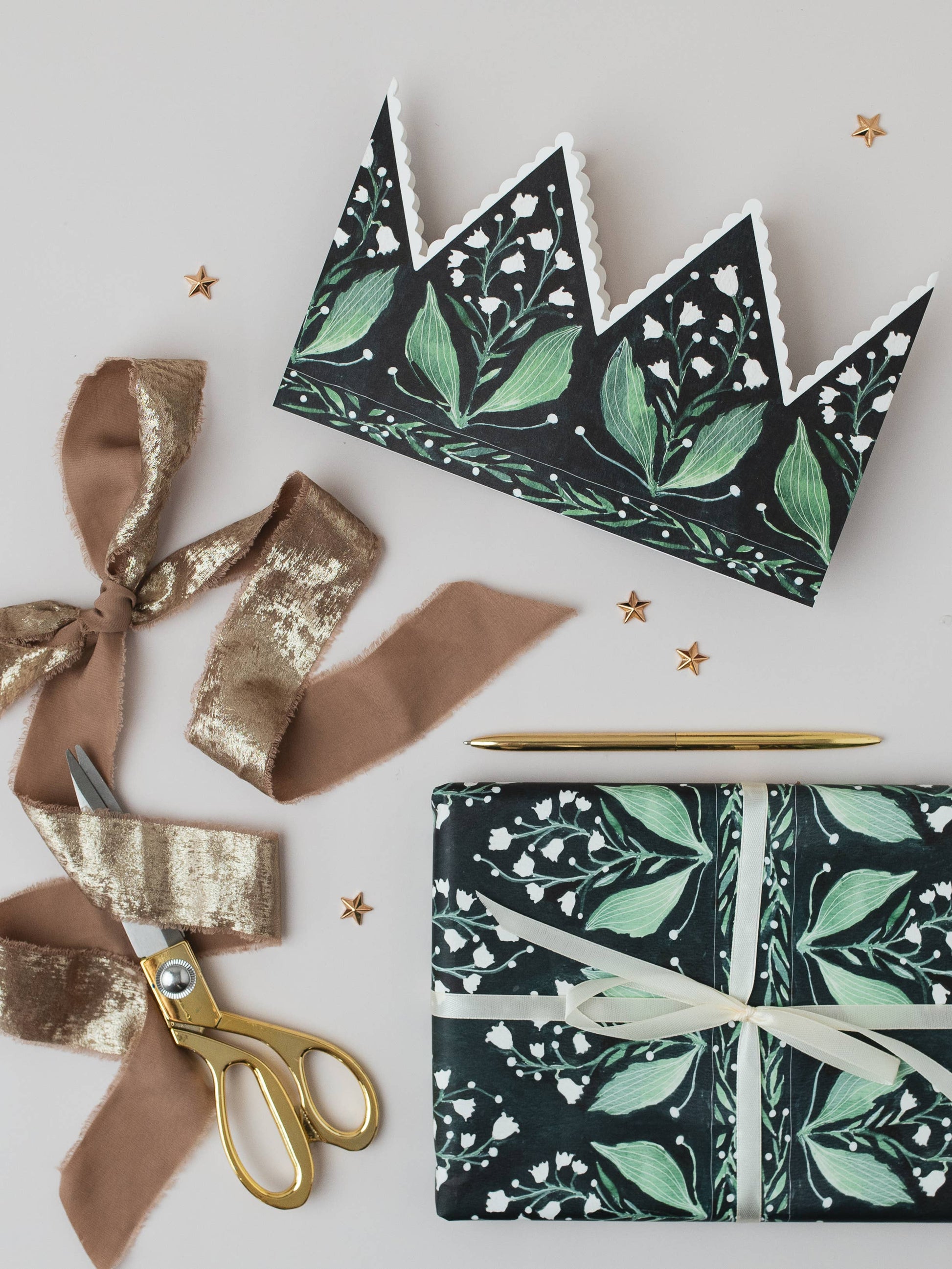 Floral-patterned gift wrap with ribbons and scissors on a light background