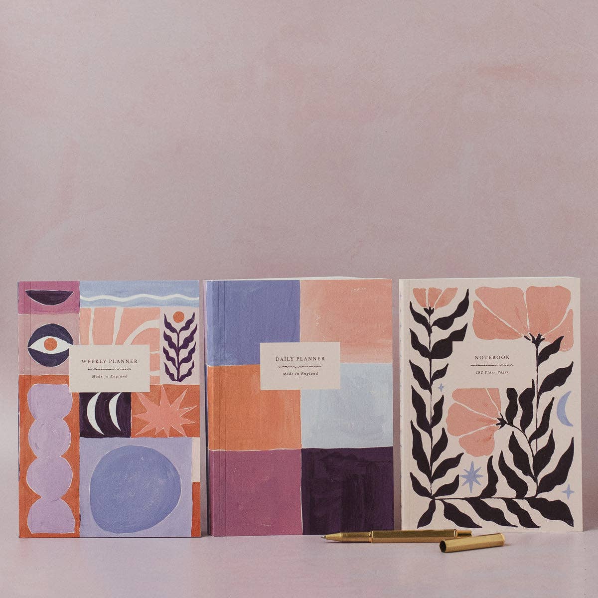 Three notebooks with geometric and floral designs on a light background