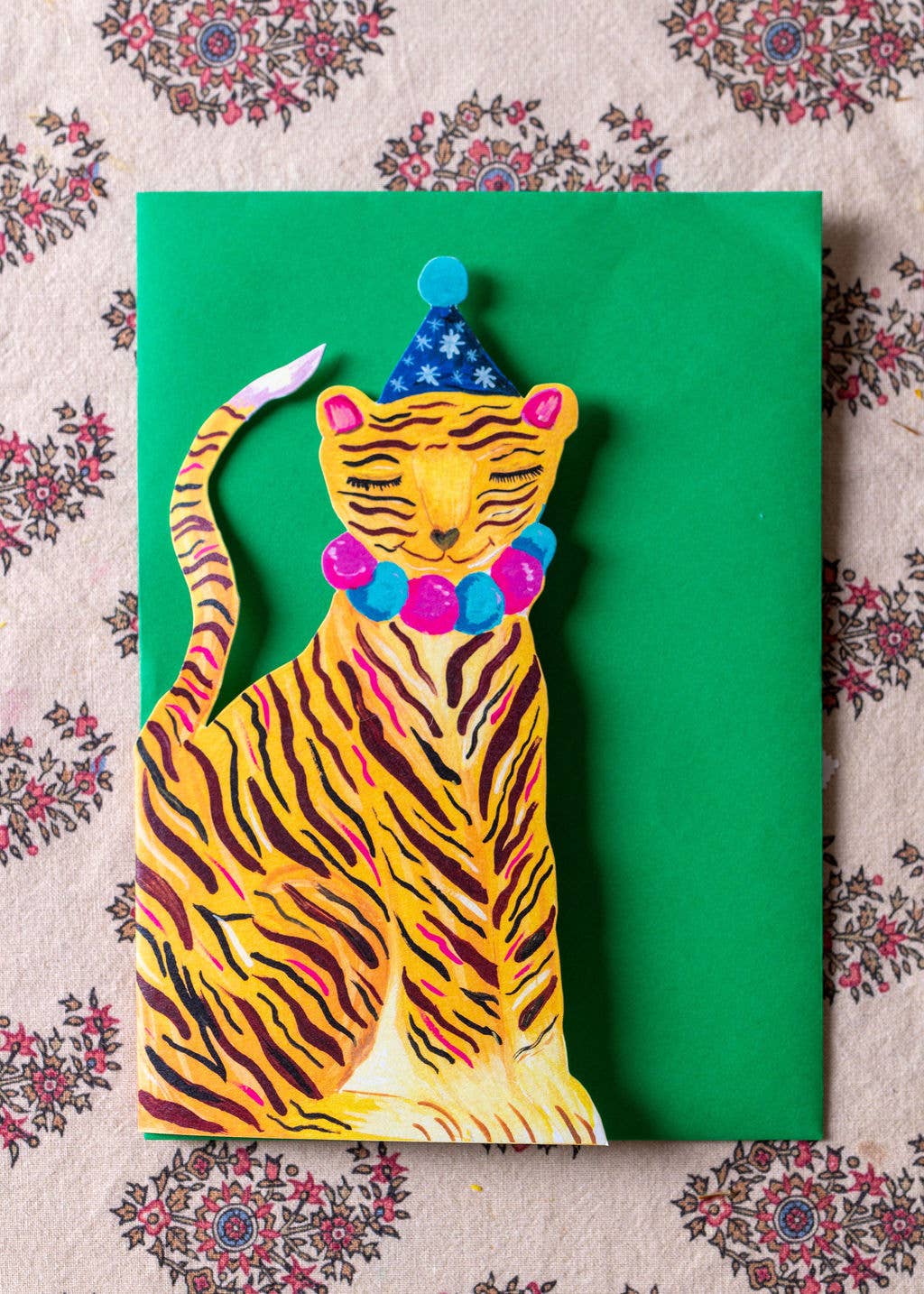 Colorful tiger illustration on a green card with decorative background