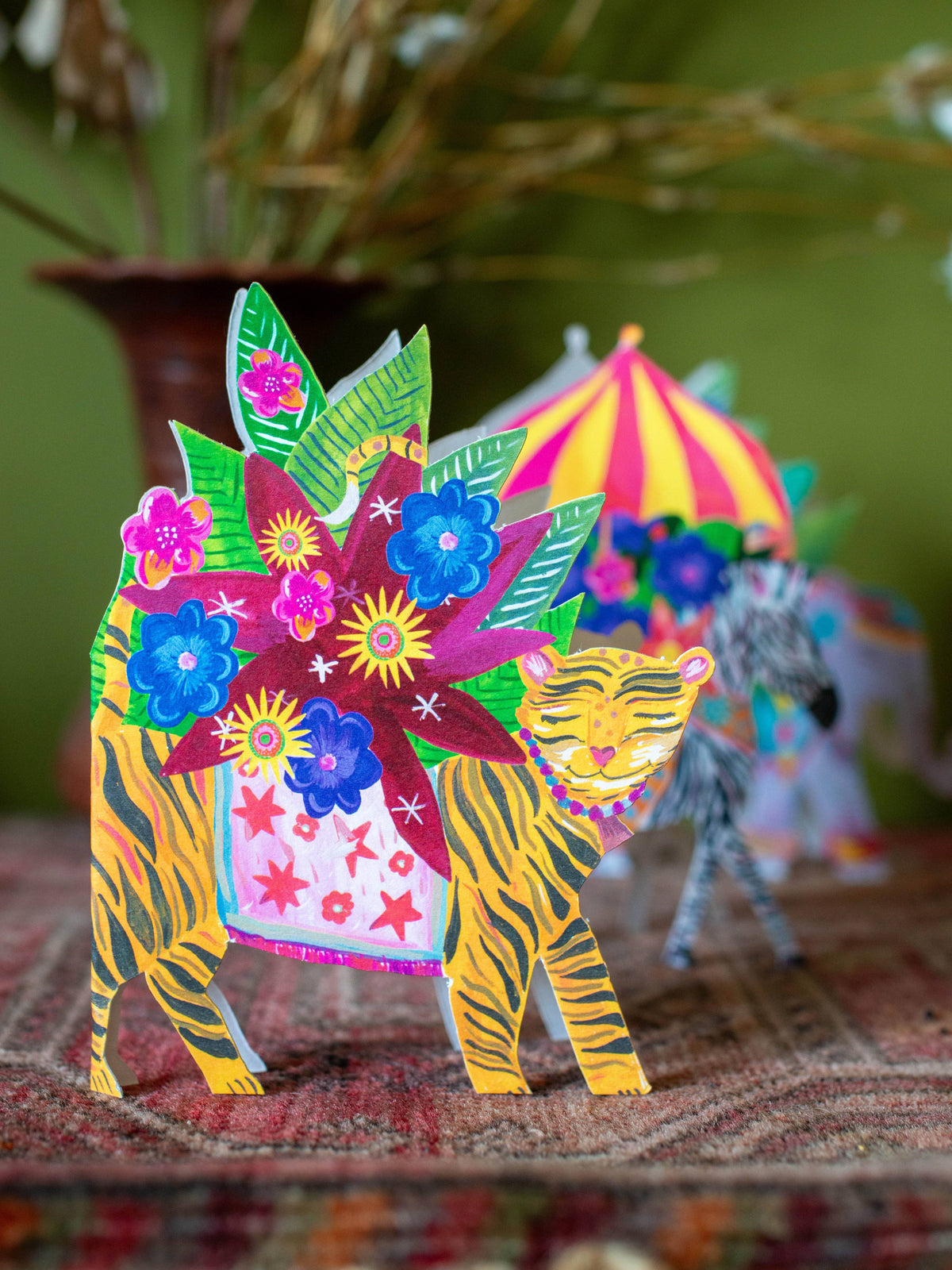 Colorful paper tiger with floral design on a textured surface