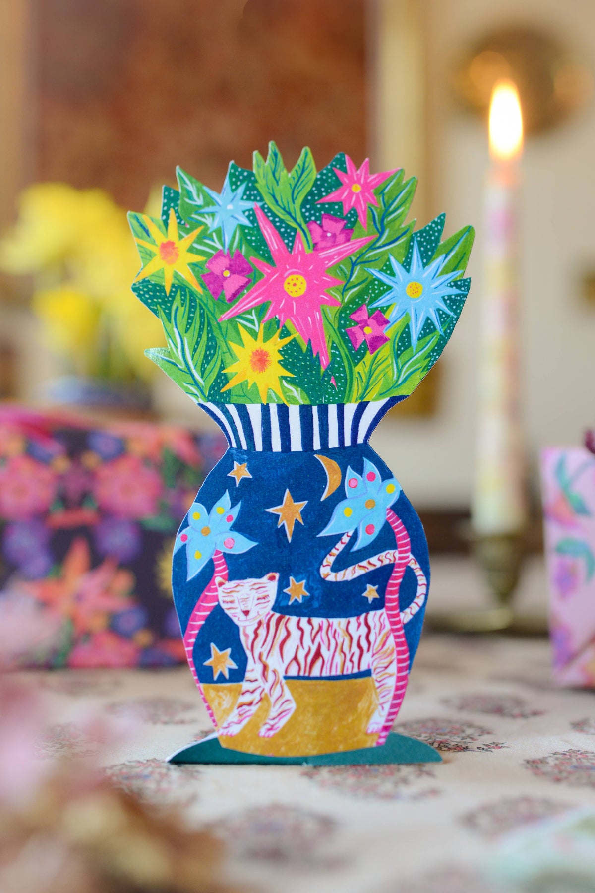 Colorful paper craft of a vase with flowers on a blurred background
