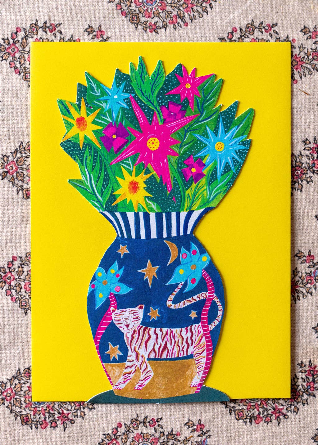 Colorful vase with flowers and a tiger design on a yellow background
