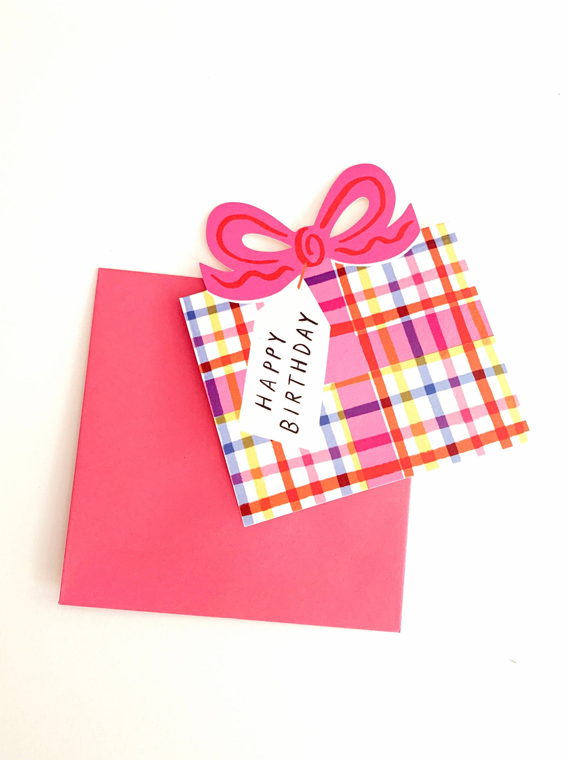 Happy Birthday card with plaid design and pink bow on a white background