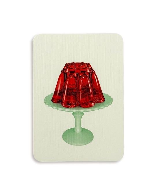 A rectangular art print or card with rounded corners, featuring a retro illustration of a red jelly mold on a mint green pedestal stand against a pale cream background.