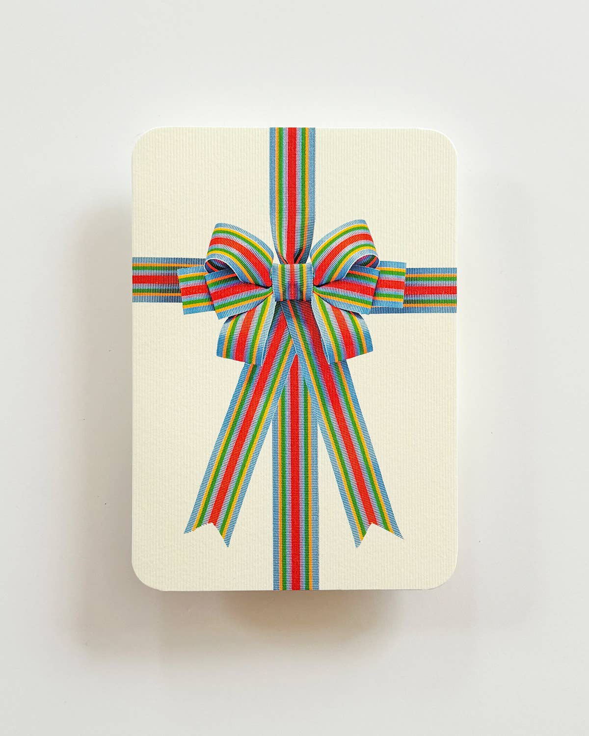 card with a colorful striped bow on a light background